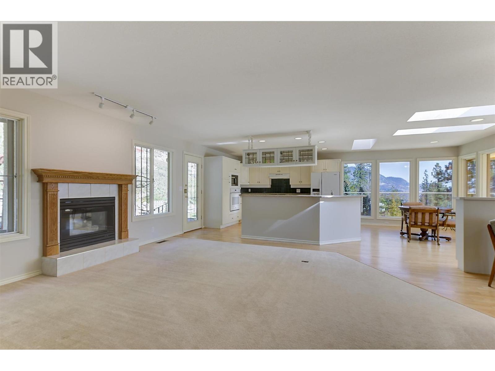Family room with gas fireplace on the upper level - 4632 / 4624 Minto Street, Peachland, BC