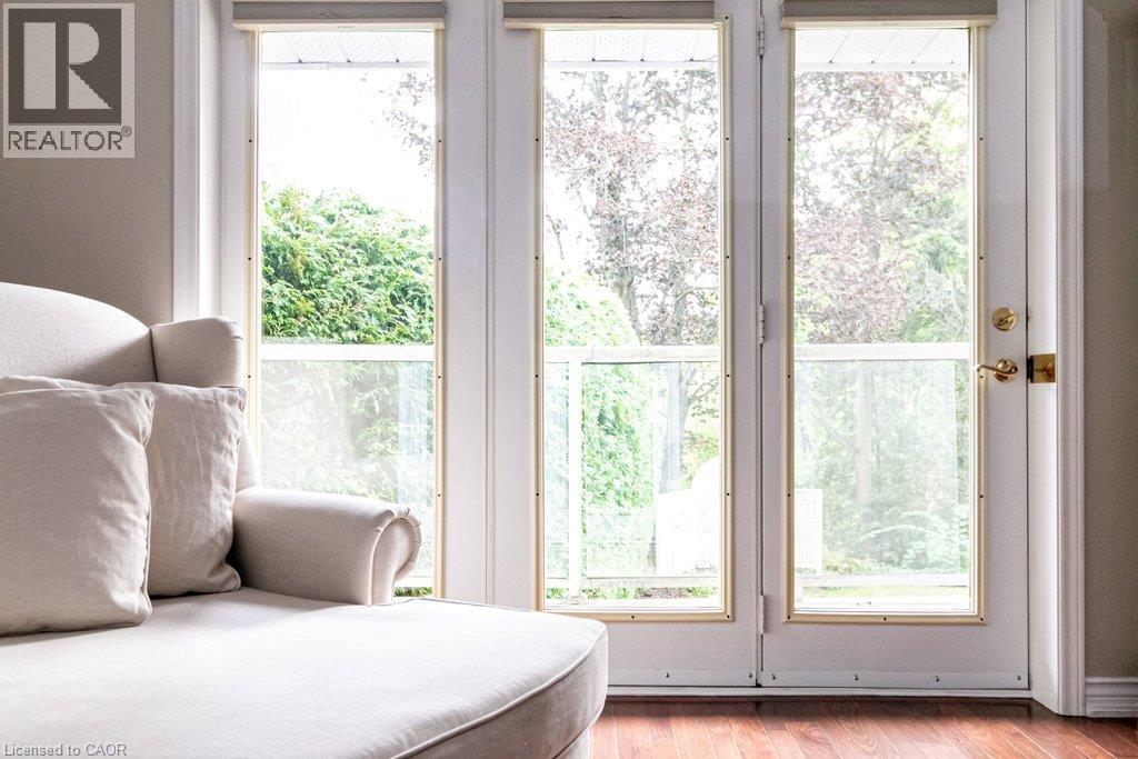 French doors with brass hardware, wood-finish flooring, and white trim - 89 Little John Road, Dundas, ON