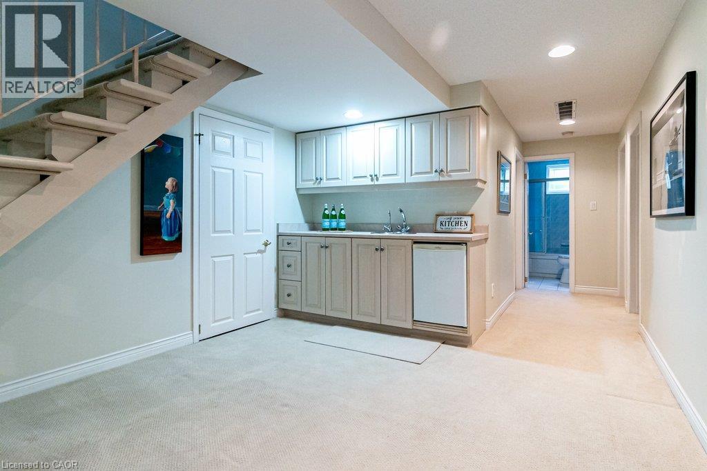 Integrated wet bar with built-in cabinetry, sink, and undercounter refrigerator - 89 Little John Road, Dundas, ON