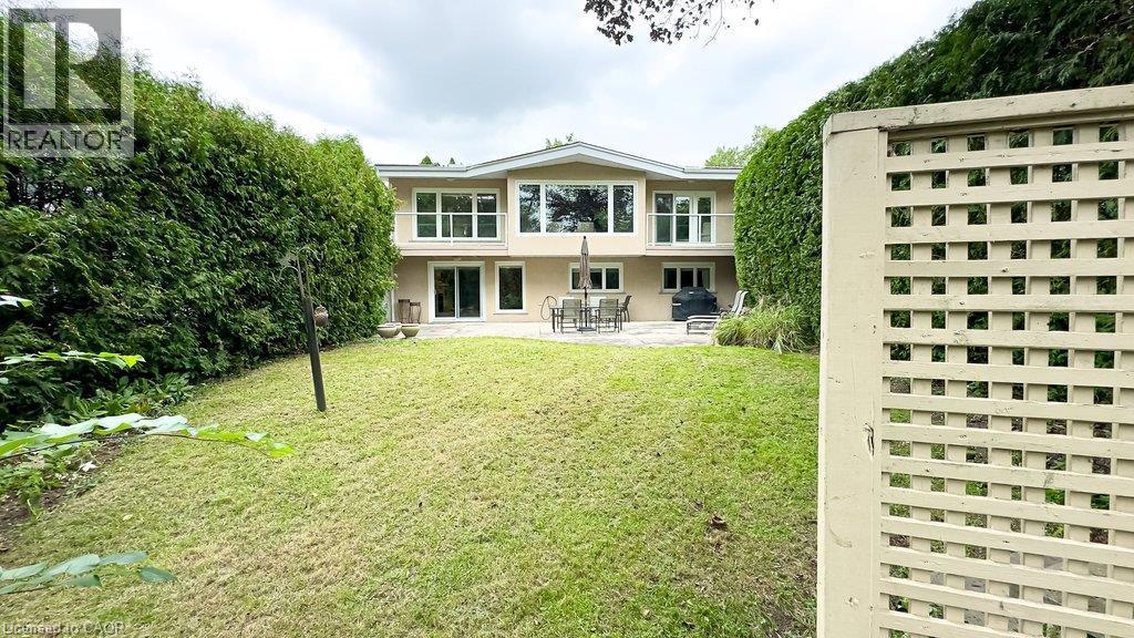 Expansive backyard with a sloped lawn and mature perimeter plantings - 89 Little John Road, Dundas, ON
