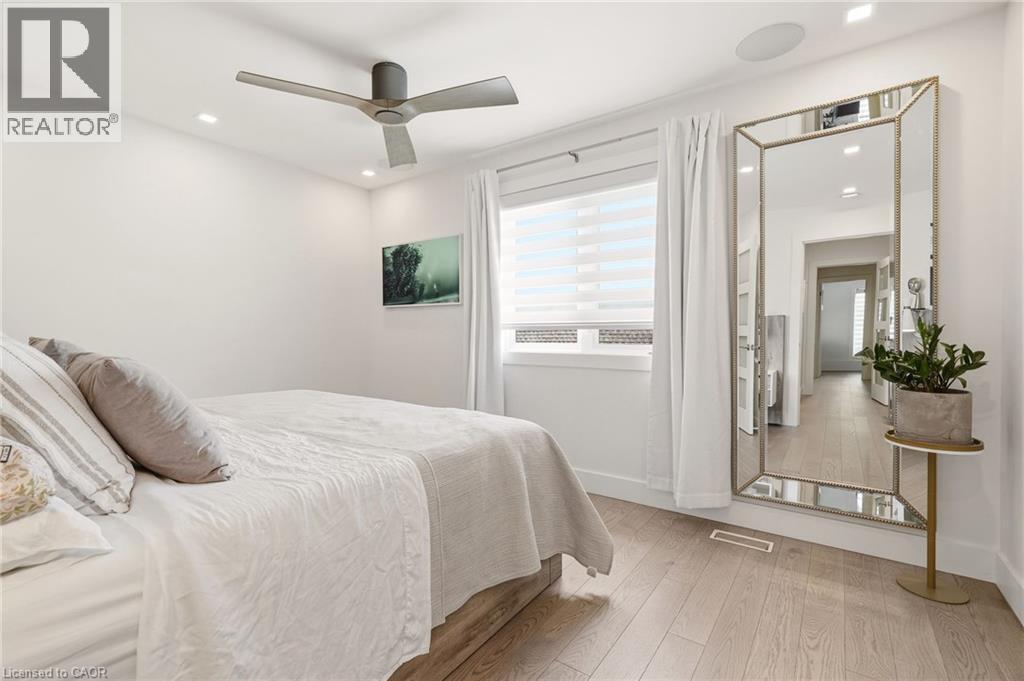 Light wood-finish flooring, recessed lighting, ceiling fan, window with blinds, and white walls - 5056 New Street Unit# 4, Burlington, ON
