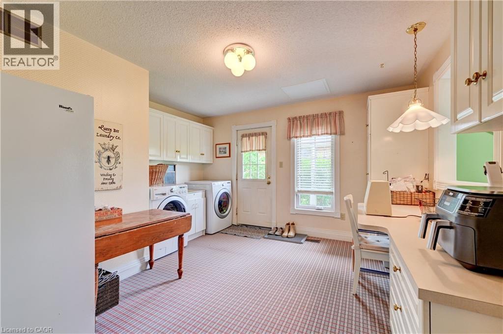 The laundry room has a door to the side porch offering you a quiet spot to enjoy your morning coffee and access to the clothes line! - 11 Lorraine Drive, Linwood, ON