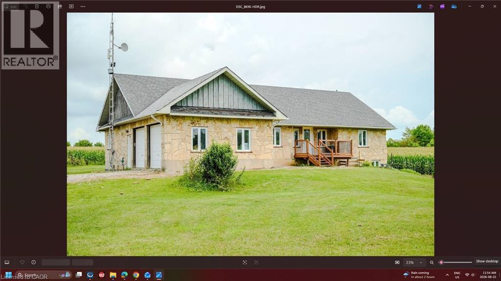 Stone exterior with dual garage doors, a multi-level deck, and a shingle roof - 107 6Th Line Line, Haldimand, ON -