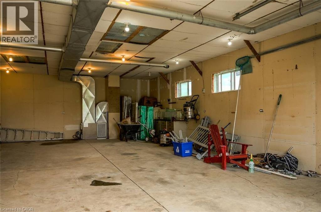 Concrete flooring, exposed ductwork, two windows, recessed lighting, wall-mounted light fixtures - 107 6Th Line Line, Haldimand, ON - Indoor Photo Showing Garage