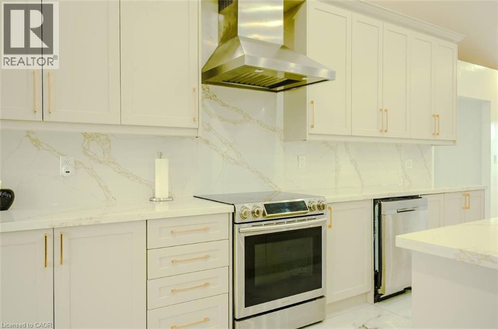 White cabinetry with gold-tone hardware, stainless steel appliances, and a range hood - 107 6Th Line Line, Haldimand, ON - Indoor Photo Showing Kitchen