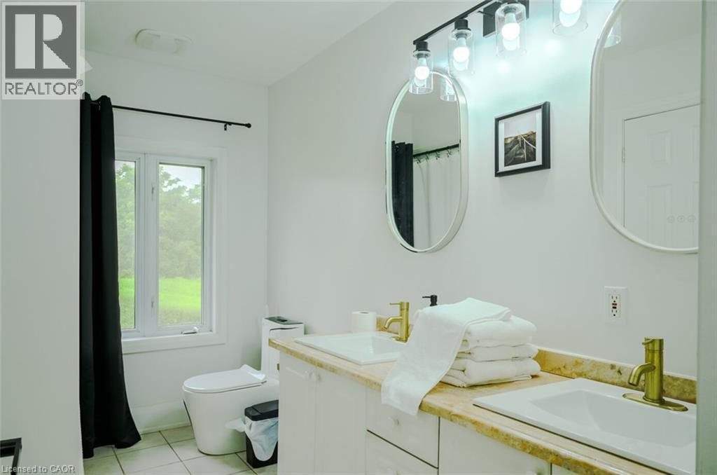 Dual vanity with undermount sinks, gold-finish faucets, and an expansive countertop - 107 6Th Line Line, Haldimand, ON - Indoor Photo Showing Bathroom