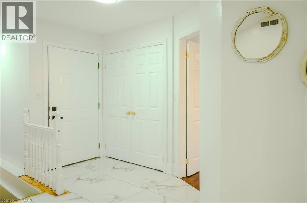 White paneled doors, white walls, and a staircase with white spindles - 107 6Th Line Line, Haldimand, ON - Indoor Photo Showing Other Room