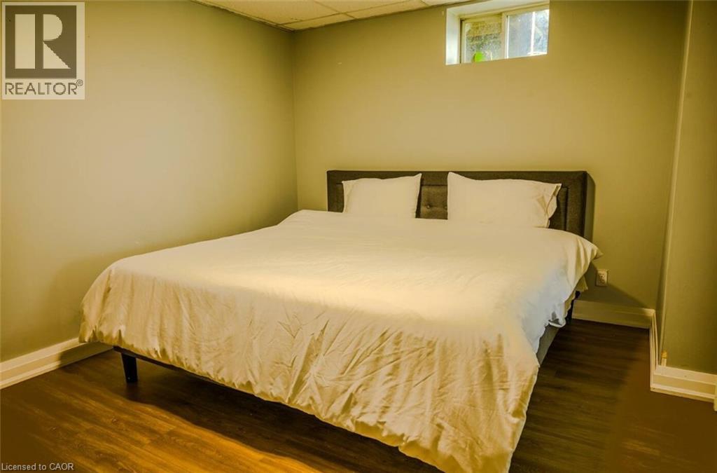 Wood-finish flooring with light wall tones and a window - 107 6Th Line Line, Haldimand, ON - Indoor Photo Showing Bedroom