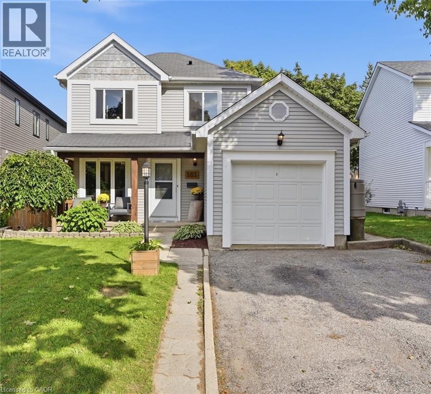 Two-story residence featuring light gray siding, a single-car garage, and a covered front porch with wood-finish support columns - 563 Westvale Drive, Waterloo, ON - Outdoor With Facade