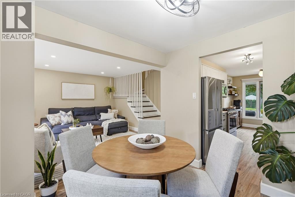 Recessed lighting, wood-finish flooring, staircase with vertical balusters, stainless steel kitchen appliances, and a kitchen window - 563 Westvale Drive, Waterloo, ON - Indoor Photo Showing Dining Room