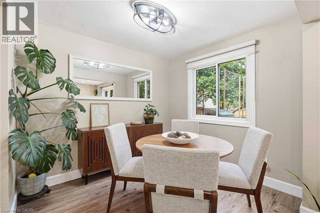 Recessed lighting with a contemporary ceiling fixture, wood-finish flooring, and a large window - 563 Westvale Drive, Waterloo, ON - Indoor Photo Showing Dining Room
