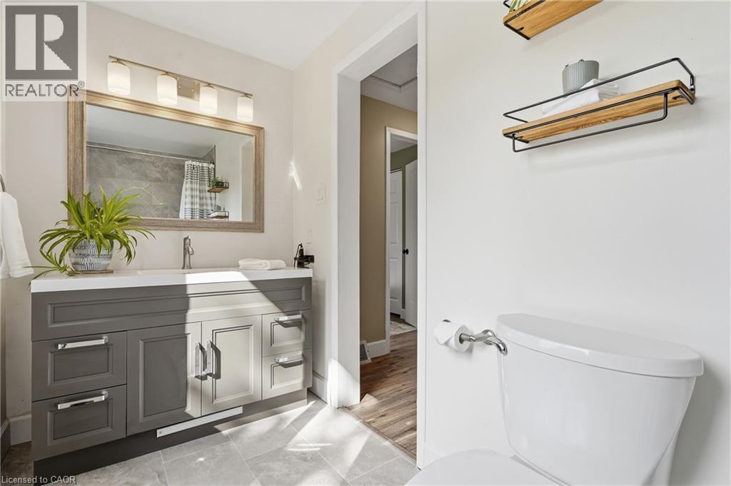 Bathroom featuring a vanity with a white countertop, rectangular sink, and dual-tone cabinetry with chrome hardware - 563 Westvale Drive, Waterloo, ON - Indoor Photo Showing Bathroom