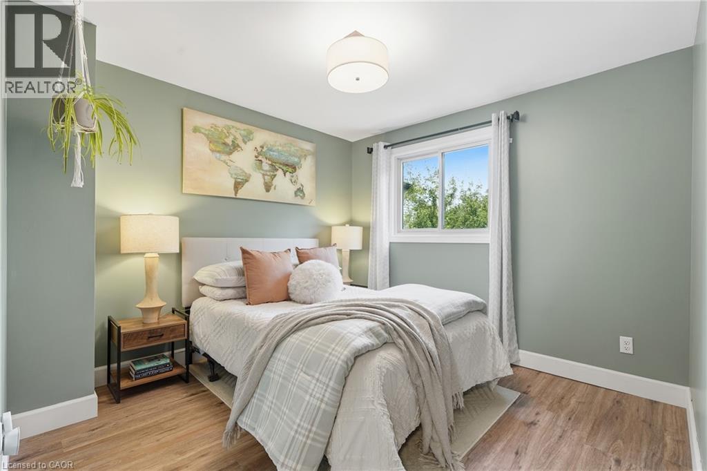 Wood-finish flooring, single window, drum ceiling light fixture, wall-mounted light switch - 563 Westvale Drive, Waterloo, ON - Indoor Photo Showing Bedroom