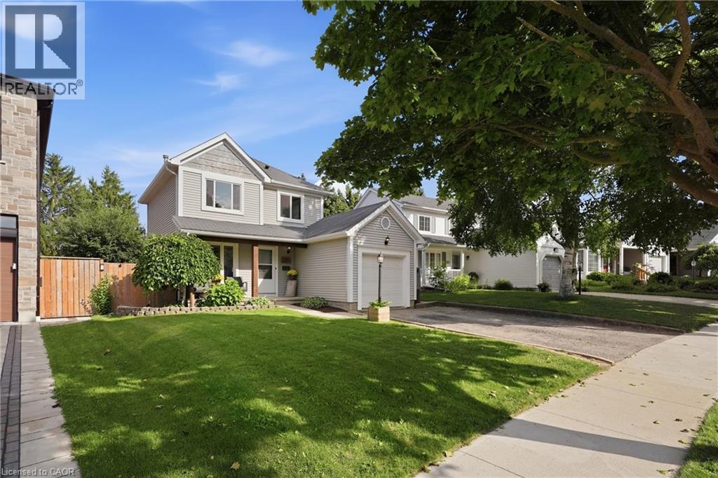 Two-story residence with light gray siding and shingle accents, featuring an attached single-car garage - 563 Westvale Drive, Waterloo, ON - Outdoor With Facade
