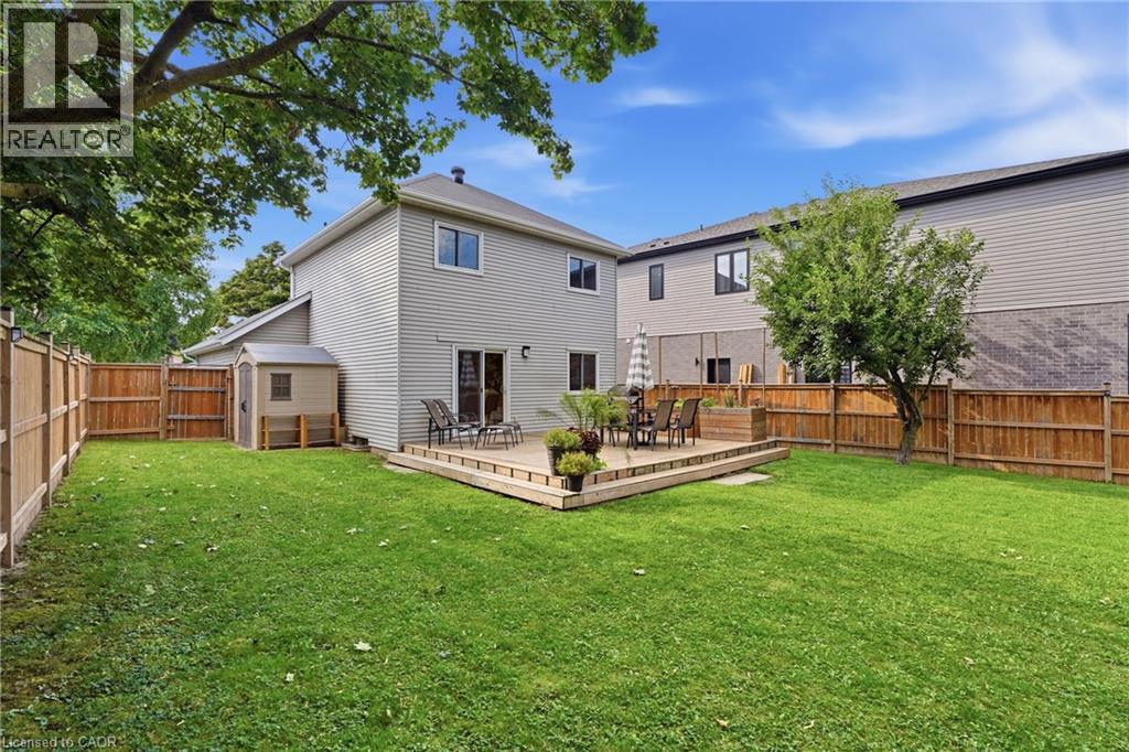Spacious backyard featuring a wood deck, wood privacy fencing, and a storage shed - 563 Westvale Drive, Waterloo, ON - Outdoor With Deck Patio Veranda With Backyard With Exterior