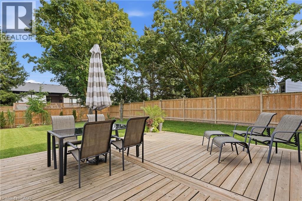Expansive wooden deck with a grassy yard and privacy fencing - 563 Westvale Drive, Waterloo, ON - Outdoor With Deck Patio Veranda