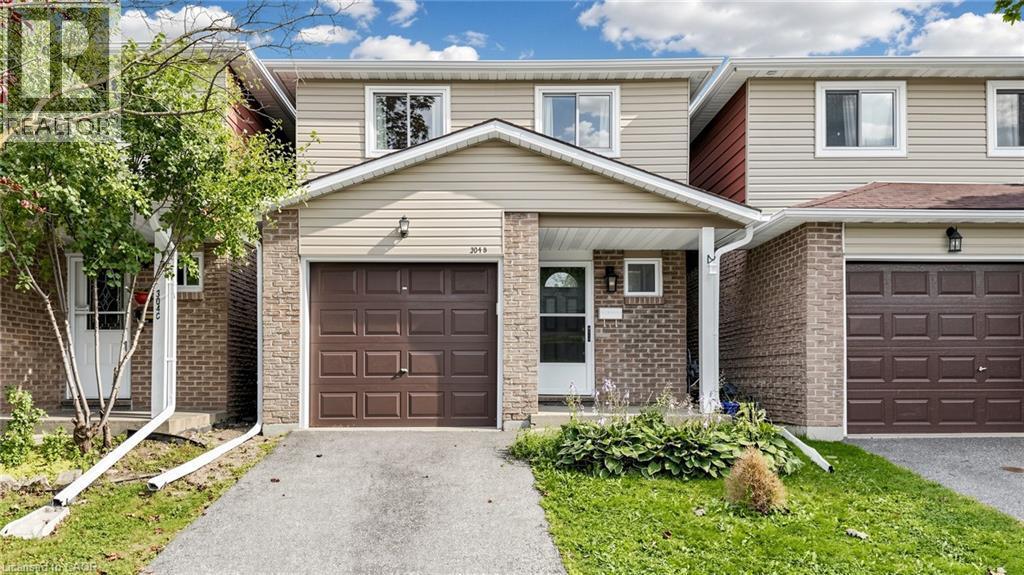 Brick and siding exterior with an attached garage, covered front entry, and front yard landscaping - 304 Bluevale Street N, Waterloo, ON - Outdoor With Facade