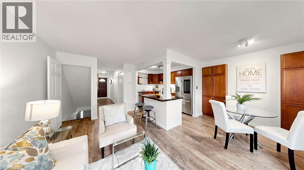 Wood-finish flooring throughout, with a kitchen featuring wood cabinetry, stainless steel appliances, and a breakfast bar - 304 Bluevale Street N, Waterloo, ON - Indoor
