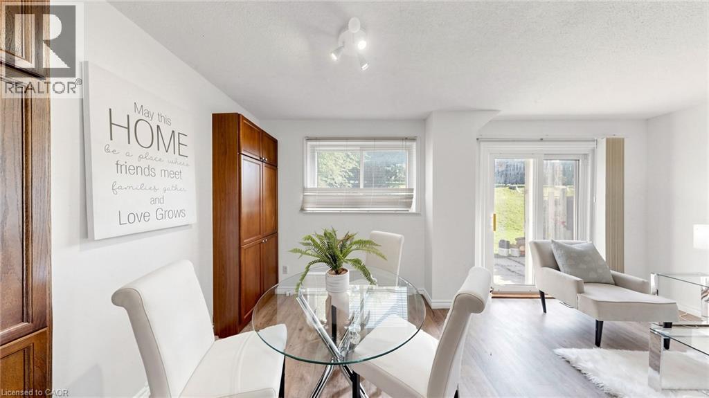 White walls with track lighting, wood-finish flooring, built-in cabinetry, and sliding glass doors to exterior - 304 Bluevale Street N, Waterloo, ON - Indoor Photo Showing Dining Room