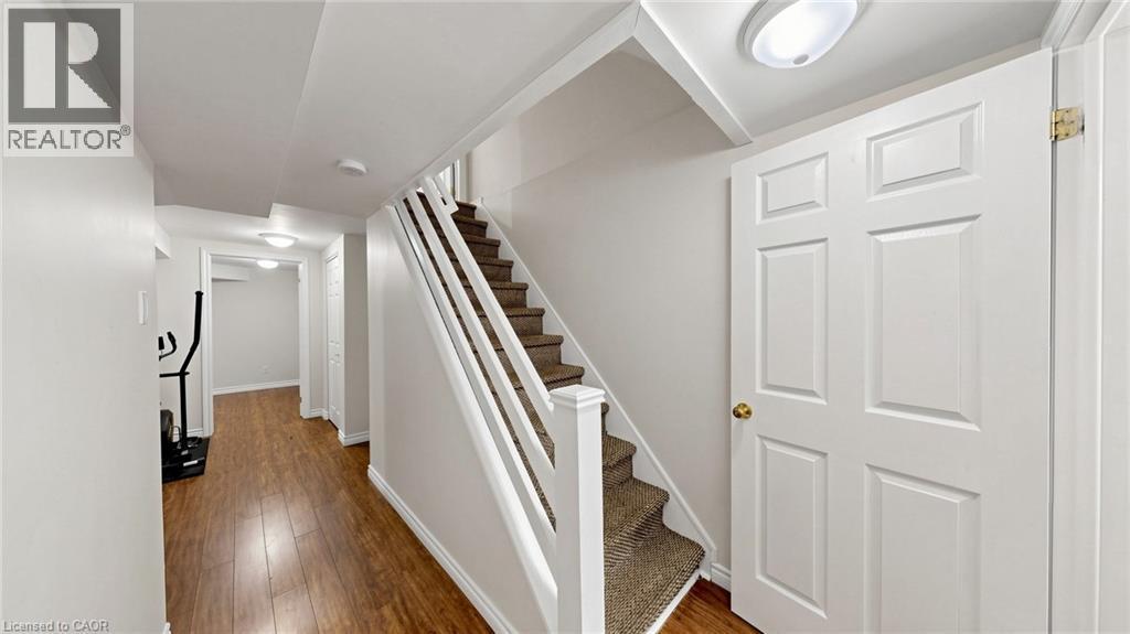 Hallway featuring wood-finish flooring and a carpeted staircase with white railings - 304 Bluevale Street N, Waterloo, ON - Indoor Photo Showing Other Room
