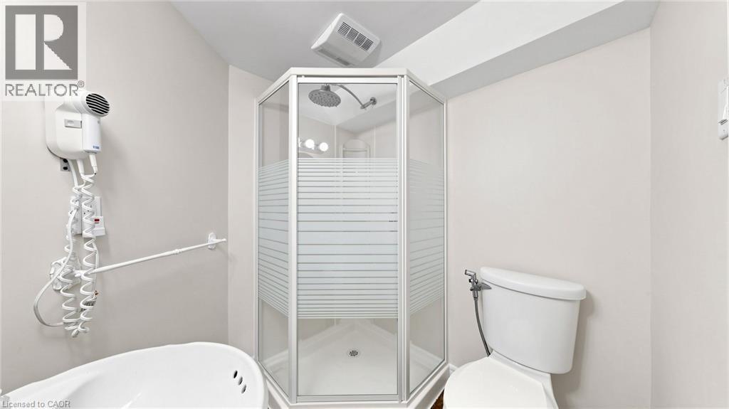 Corner shower stall with frosted glass panels and a white base, adjacent to a white toilet - 304 Bluevale Street N, Waterloo, ON - Indoor Photo Showing Bathroom