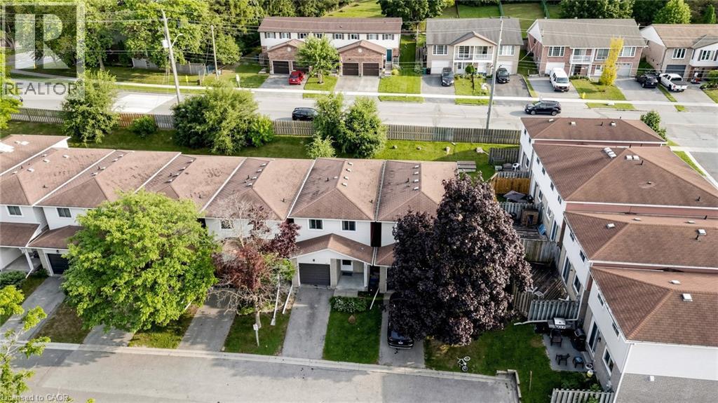 Townhome community with attached garages, paved driveways, and mature landscaping - 304 Bluevale Street N, Waterloo, ON - Outdoor With Facade
