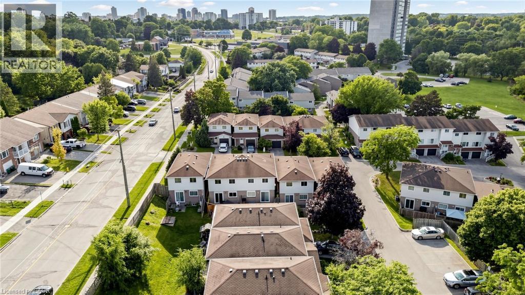 Residential street with established trees, multiple townhome-style residences, and distant urban skyline - 304 Bluevale Street N, Waterloo, ON - Outdoor With View