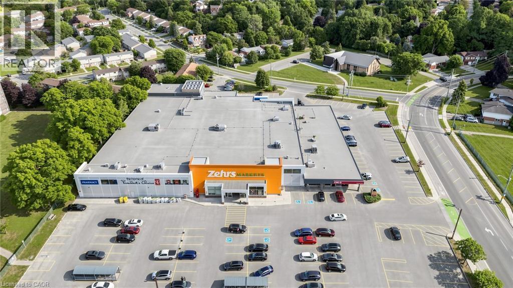 Expansive commercial property featuring a large parking area, surrounding roadways, and visible retail storefronts - 304 Bluevale Street N, Waterloo, ON - Outdoor With View