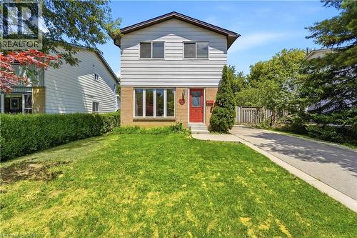 Two-story residence featuring a red entry door, light-colored siding, and brick accents - 23 Heatherdale Place, Hamilton, ON - Outdoor
