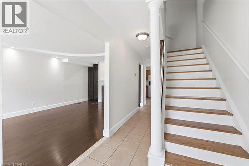 Hardwood flooring, curved architectural detail, recessed lighting, white wood staircase, and tile flooring - 23 Heatherdale Place, Hamilton, ON - Indoor Photo Showing Other Room