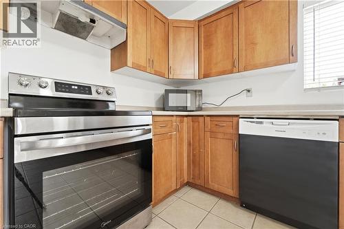 Full kitchen featuring wood cabinetry, light-toned countertops, and tile flooring - 23 Heatherdale Place, Hamilton, ON - Indoor Photo Showing Kitchen