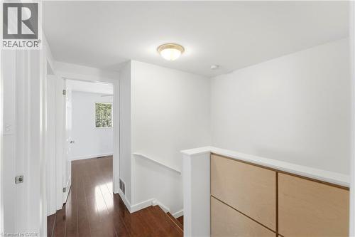 Hardwood flooring, painted white walls, recessed lighting, and a light wood-paneled half-wall - 23 Heatherdale Place, Hamilton, ON - Indoor Photo Showing Other Room