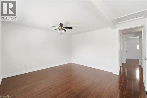 Wood-finish flooring throughout, ceiling fan with integrated lighting, and white walls - 23 Heatherdale Place, Hamilton, ON - Indoor Photo Showing Other Room