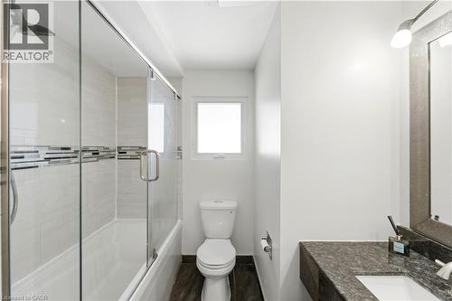Glass-enclosed shower-tub combination with a rain showerhead, mosaic tile accent band, and light-toned wall tile - 23 Heatherdale Place, Hamilton, ON - Indoor Photo Showing Bathroom