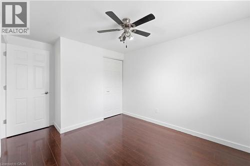 Rich wood-finish flooring, bright white walls, and a ceiling fan with integrated lighting - 23 Heatherdale Place, Hamilton, ON - Indoor Photo Showing Other Room