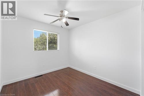Wood-finish flooring, white walls, ceiling fan with integrated lighting, and a window with horizontal blinds - 23 Heatherdale Place, Hamilton, ON - Indoor Photo Showing Other Room