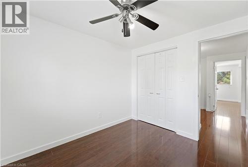 Wood-finish flooring, bright white walls, ceiling fan with integrated lighting, and bi-fold closet doors - 23 Heatherdale Place, Hamilton, ON - Indoor Photo Showing Other Room