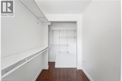 Walk-in closet featuring wood-finish flooring, white walls, and built-in shelving units - 23 Heatherdale Place, Hamilton, ON - Indoor Photo Showing Other Room