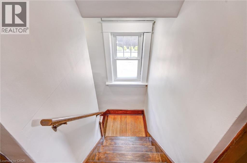 Hardwood staircase with a wood handrail - 147 Courtland Avenue E, Kitchener, ON - Indoor Photo Showing Other Room