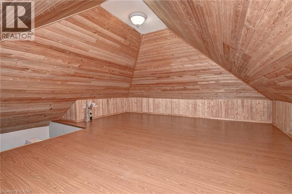 Expansive loft space featuring wood-finish flooring, sloped wood-paneled ceilings, and wood-paneled wainscoting - 147 Courtland Avenue E, Kitchener, ON - Indoor Photo Showing Other Room