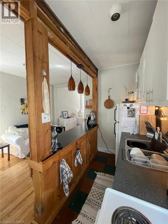 Kitchen featuring wood-finish cabinetry, a single basin sink, and a refrigerator - 80 E Byron Avenue E Unit# 2, London, ON - Indoor Photo Showing Other Room