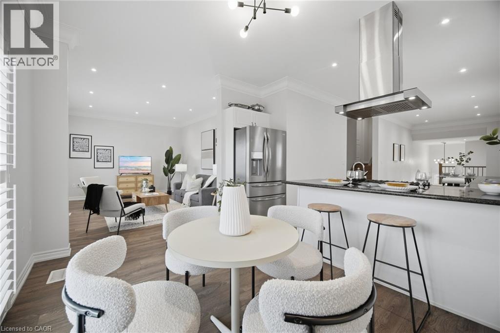 Recessed lighting throughout, stainless steel appliances, a kitchen island with seating, wood-finish flooring, and crown molding - 20 Todd Crescent, Dundalk, ON - Indoor