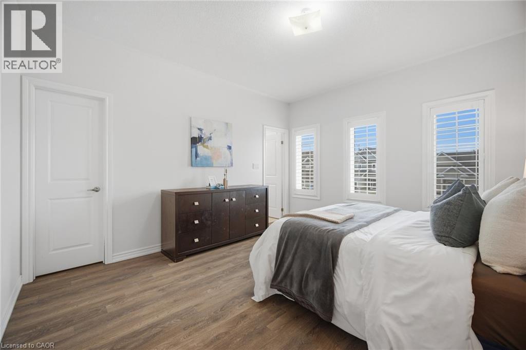 Wood-finish flooring, white walls, and multiple windows with plantation shutters - 20 Todd Crescent, Dundalk, ON - Indoor Photo Showing Bedroom