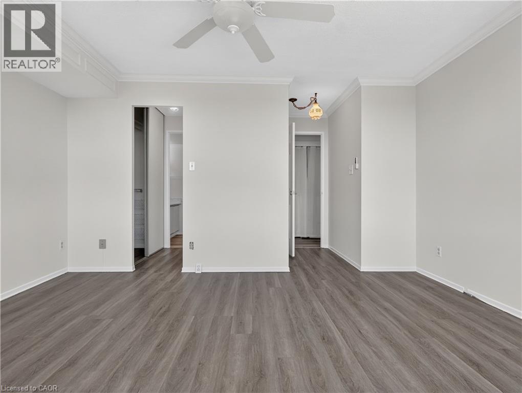 Wood-finish flooring, crown molding, ceiling fan, and recessed light fixture - 7 Gale Crescent Unit# 1107, St. Catharines, ON
