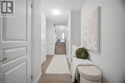 Tiled flooring, white paneled doors, light neutral wall color, and a staircase with wood-finish treads -