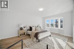 Bright room featuring a bay window, wood-finish flooring, recessed lighting, and a neutral color palette -