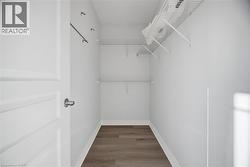 Walk-in closet featuring wood-finish flooring, white wire shelving, and a garment rod -
