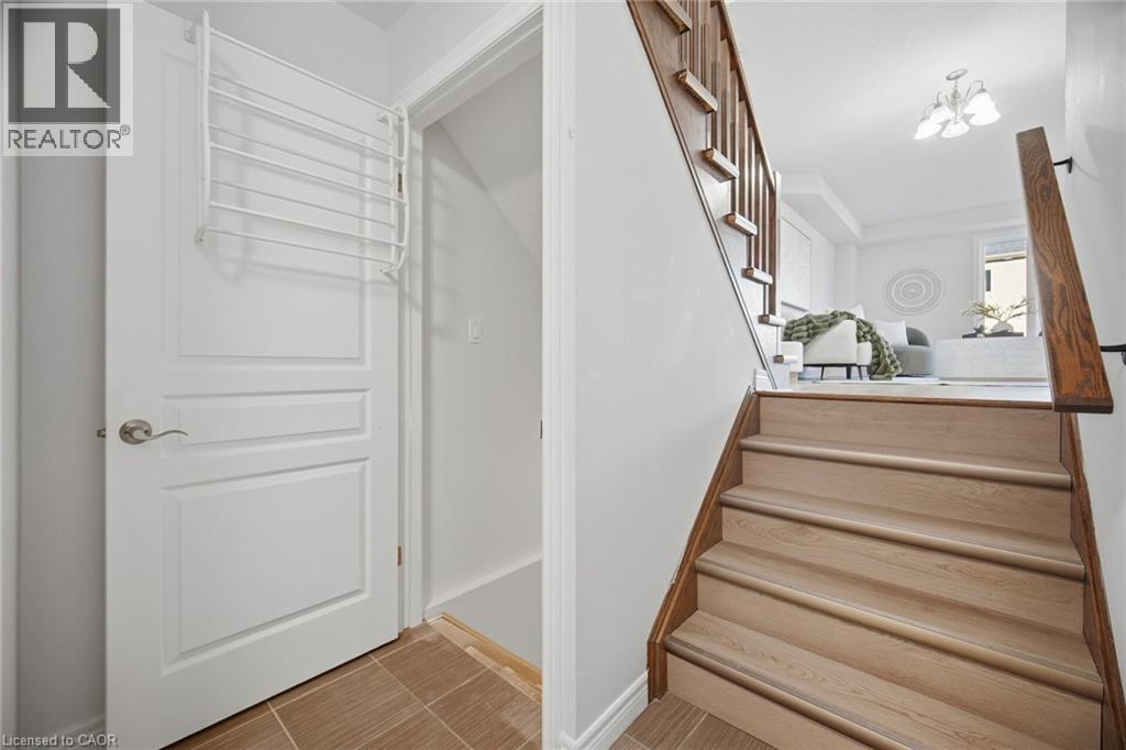 Hardwood staircase with natural wood treads and dark wood banister - 98 Bloom Crescent, Stoney Creek, ON