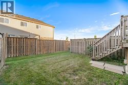 Fenced backyard with wood privacy fencing, a wood deck, and wood stairs -