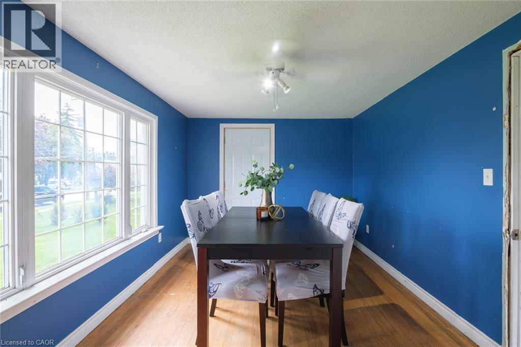 Hardwood-style flooring, large multi-pane windows, a ceiling-mounted light fixture, and a white interior door - 78 Oak Street, Simcoe, ON